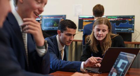 Members of UNH's student-run investment fund, Atkins Investment Group, gather in the college's Bloomberg Terminal room.