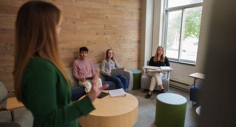 UNH Students gather for a private tutoring session with Management professor Rachel Campagna in the Forge, Paul College's dedicated space for Business in Practice programs.