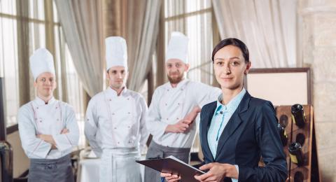 Woman in business attire and men in chef uniforms