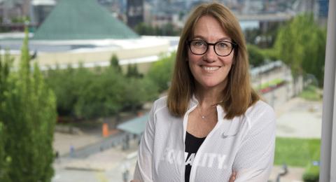 Amy White '86 standing in front of a window at Nike Headquarters 