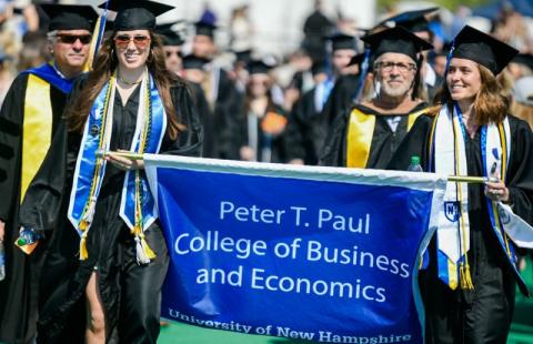 paul college students carrying the college banner at 2022 commencement