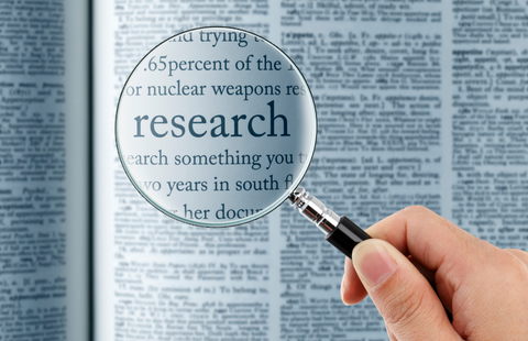 image of magnifying glass hovering over the word research in the dictionary