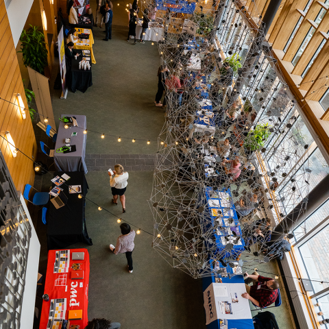 Bird's eye view of conference attendees perusing booths in the Great Hall