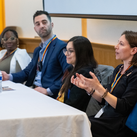 Four panelists sit at a table