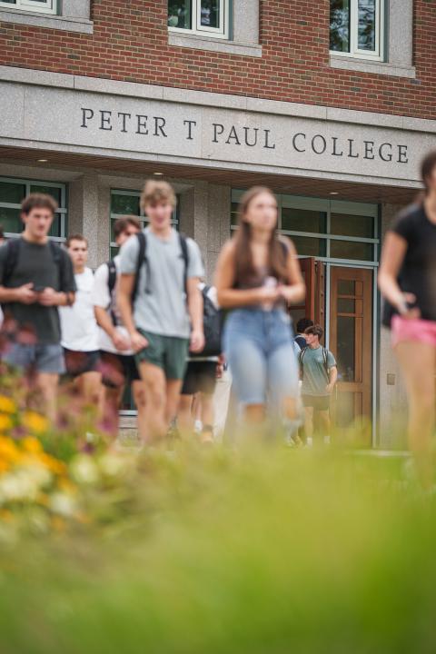 to college students walking in from of the UNH Paul College of Business and Economics