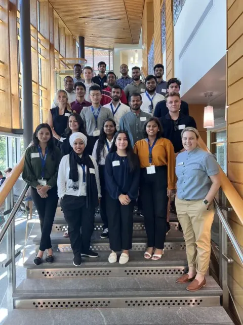 students from the master's in finance class in a group photo on the stairs of UNH Paul College