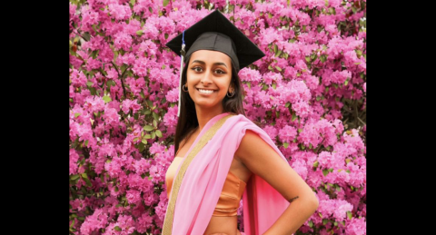 Justine Jonathan graduation photo in front of pink flowers