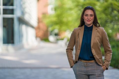 A female student poses for the camera in business attire.