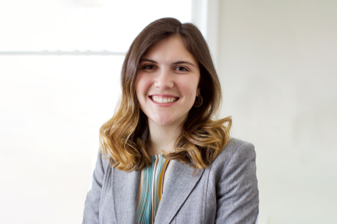 A female student smiling at the camera in business atire.