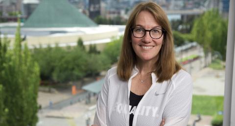 Amy White '86 standing in front of a window at Nike Headquarters 
