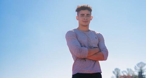 Adrian Sutton stands, backlit by the sun, with his arms crossed