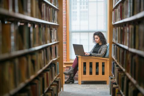Online MBA student studying in library online-mba-student-studying-in-library