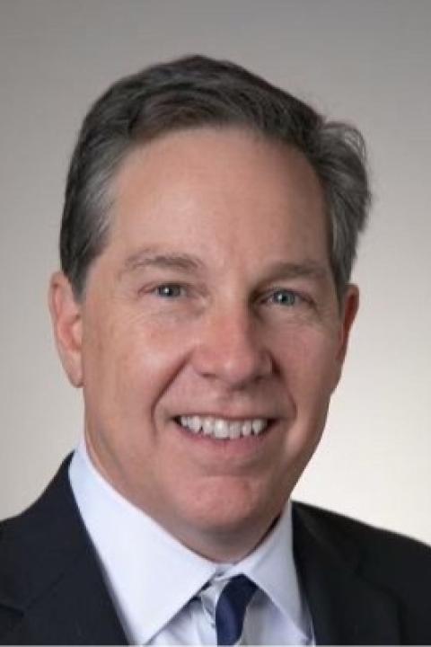 Copilot said:  Head-and-shoulders portrait of Andy Pelletier wearing a dark suit and tie against a gray background.